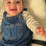 Milann a rejoint le concours — aidez-le/la à gagner de superbes lots ! baby, child, closeup, clothing, comfortable, cute, denim_overalls, expression, face, fluffy_cushion, furniture, hand, happy, indoors, infant, portrait, seated, skin, smiling, striped_shirt