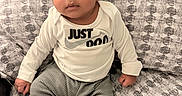 Ahmaad joined the competition — help win amazing prizes! baby, infant, child, portrait, sitting, bed, bedspread, patterned_fabric, striped_clothing, hat, onesie, socks, white_clothing, fashion, face, eyes, looking_at_camera, indoors, bedroom, nike_logo