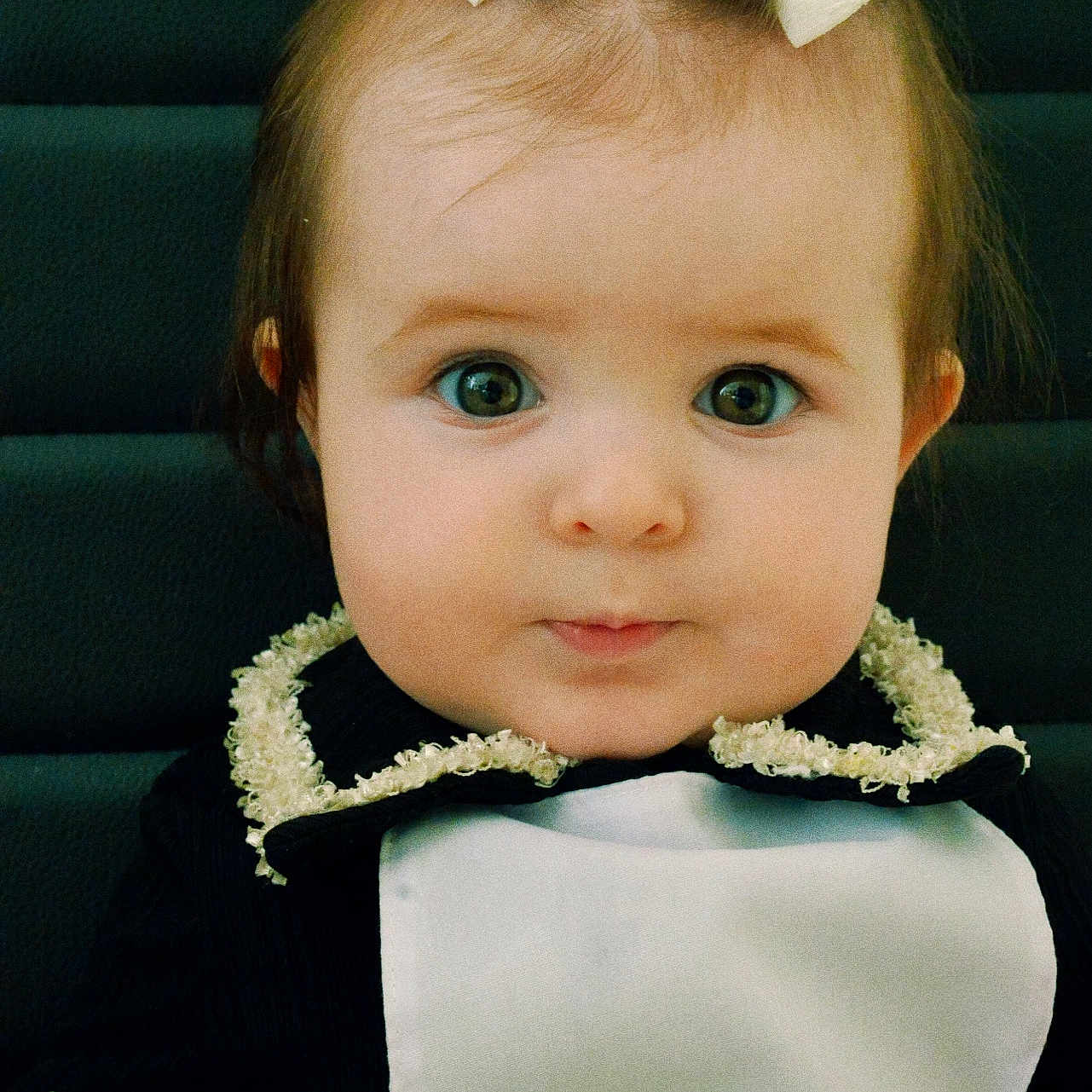 Anisia joined the competition — help win amazing prizes! baby, black_clothing, bow, child, closeup, curious_eyes, cute, expression, face, fashion, hair, hands, indoors, infant, lace, person, portrait, sitting, white_clothing, young_child