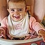 Diana is registered to the contest to win money with this photo: baby, child, high_chair, smiling, pink_bow, bib, toy_piano, indoor, happy, cute, infant, clothing, face, person, seat, playful, cheerful, young_child, close_up, colorful