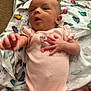 Everleigh is registered to the contest to win money with this photo: baby, infant, pink_onesie, strawberry, blanket, patterned_blanket, reaching_hand, wide_eyes, open_mouth, lying_down, newborn, cute, child, soft_fabric, skin, small_hands, small_feet, expressive_face, indoors, person