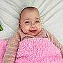 baby, smiling, blanket, pink, infant, cute, face, child, happy, lying_down, soft_texture, cozy, portrait, clothing, sleeves, skin, head, eyes, mouth, indoors
