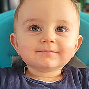 Eden participe au concours pour gagner de l'argent avec cette photo : baby, blue_chair, casual_clothing, child, close_up, curious, cute, expression, face, happy, indoor, navy_shirt, person, portrait, sitting, small_whale, smiling, spiked_hair, text_on_clothing, young_child