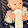 baby, baby_carrier, child, closeup, clothing, cute, face, feeding, hands, head, holding, indoors, infant, milk, milk_bottle, milk_feeding, portrait, sitting, striped, young