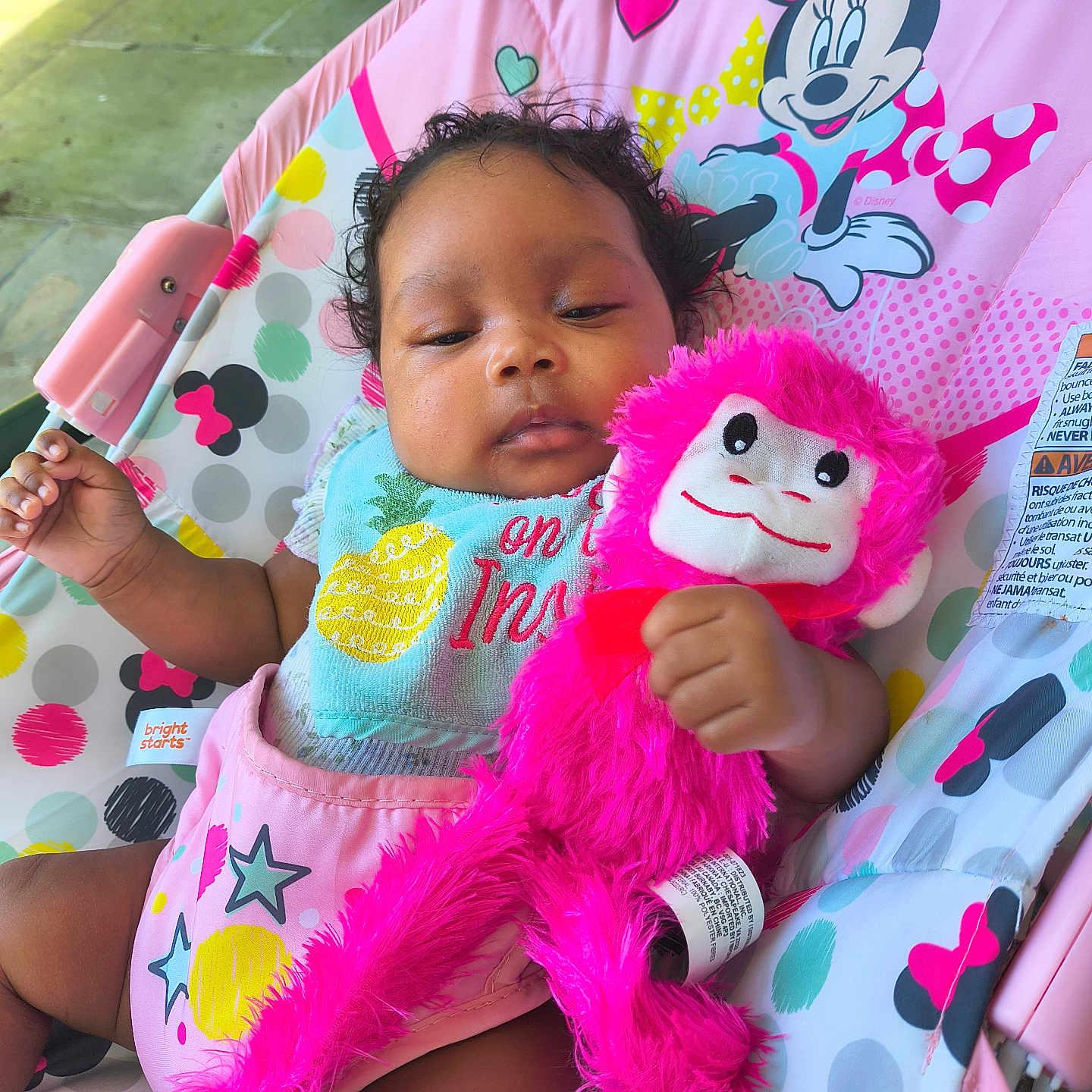 Cassidy is registered to the contest to win money with this photo: baby, infant, toy, plush_toy, pink, mickey_mouse, minnie_mouse, baby_seat, colorful, outdoor, child, cute, relaxed, clothing, bib, patterned, smile, hand, face, curly_hair