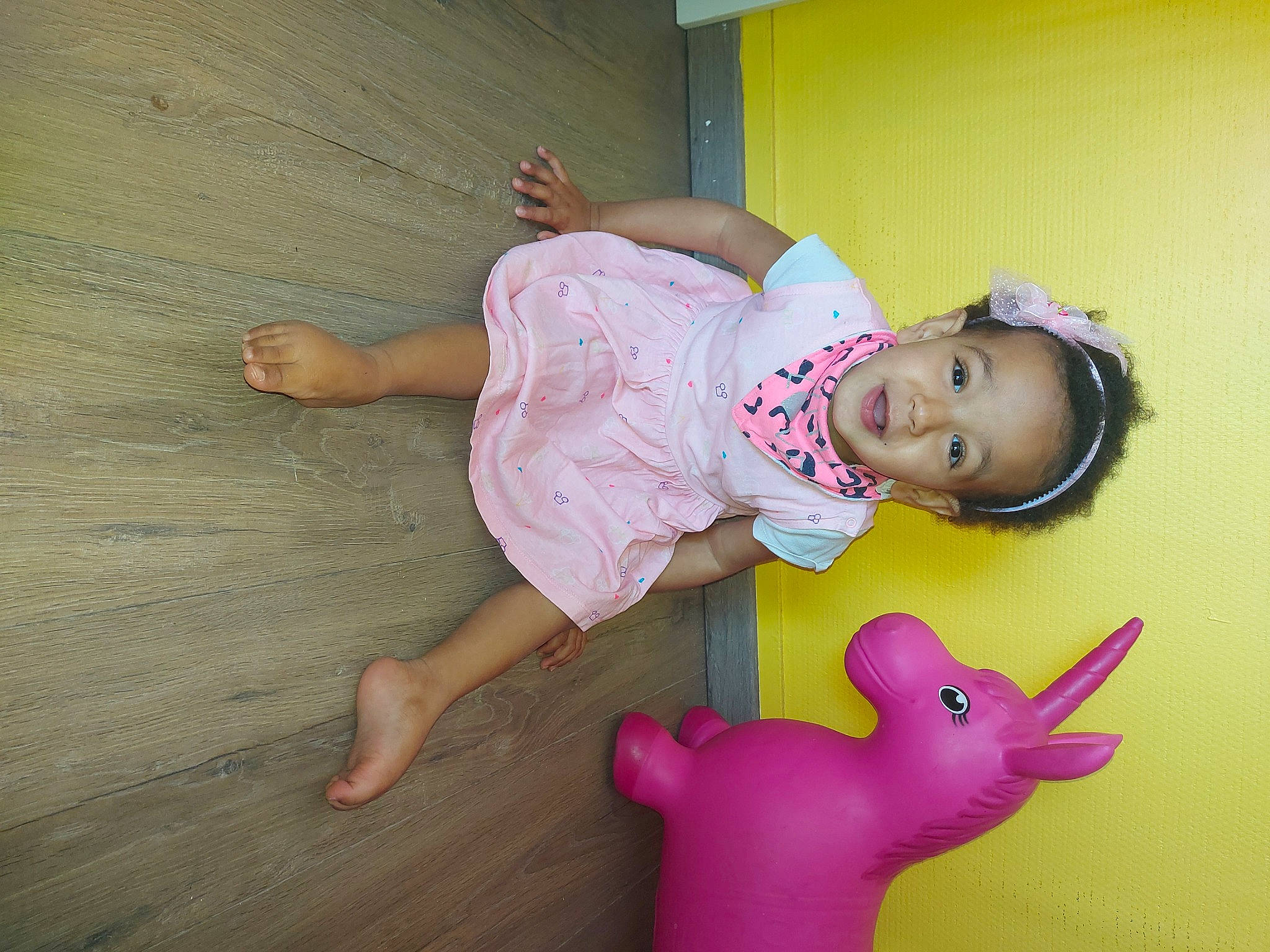 Asma a rejoint le concours — aidez-le/la à gagner de superbes lots ! baby_toddler_clothing, child, facial_expression, finger, flooring, foot, fun, happy, hardwood, human_leg, joint, magenta, mammal, person, pink, skin, thigh, toddler, toy, wood