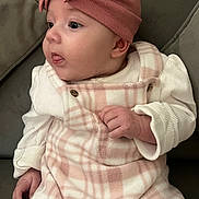 Hope-Dotty joined the competition — help win amazing prizes! baby, child, infant, face, headband, pink, plaid, clothing, couch, furniture, hand, tongue, curious, cute, indoor, portrait, soft, warm, cozy, person