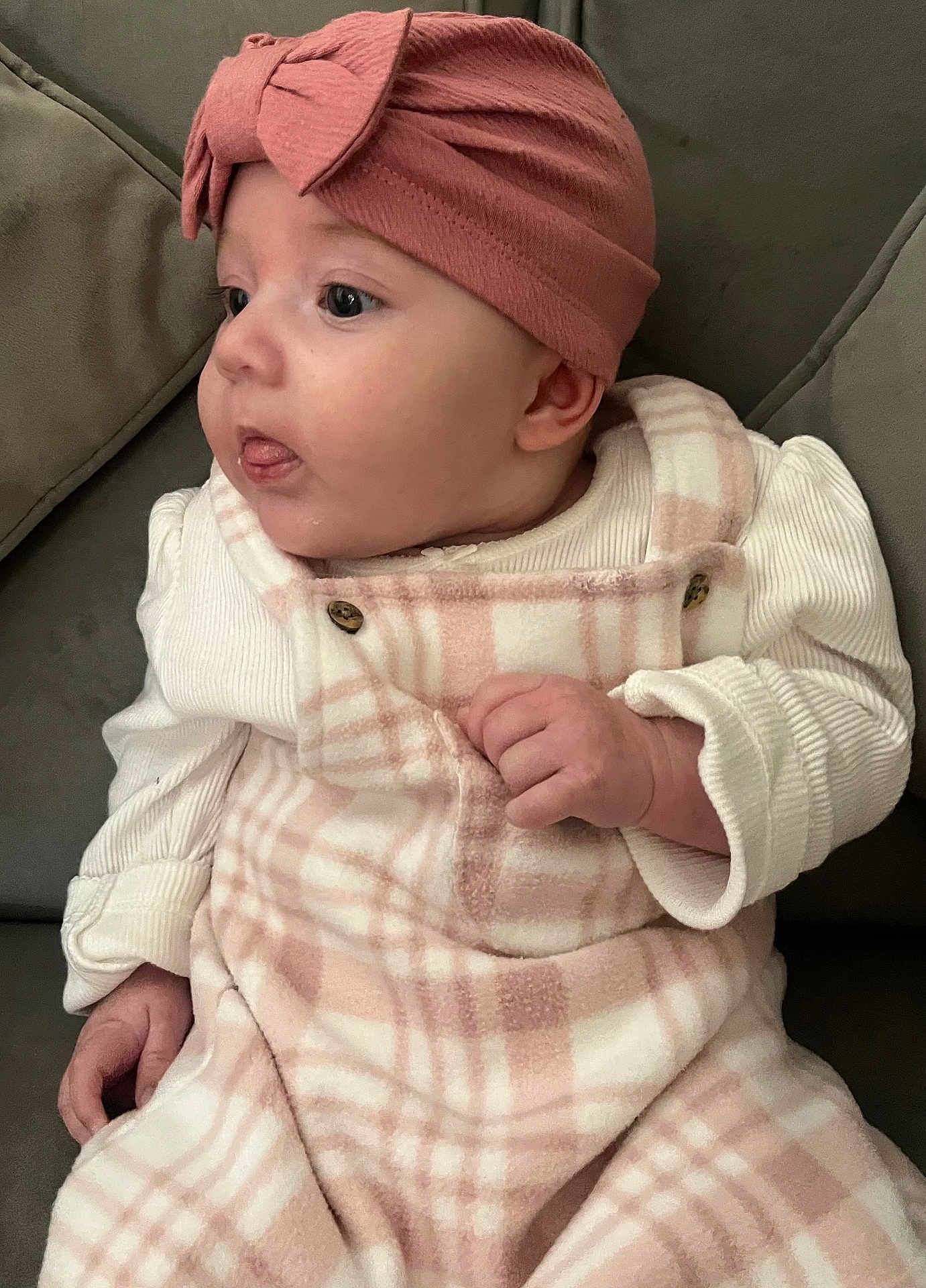 Hope-Dotty joined the competition — help win amazing prizes! baby, child, infant, face, headband, pink, plaid, clothing, couch, furniture, hand, tongue, curious, cute, indoor, portrait, soft, warm, cozy, person