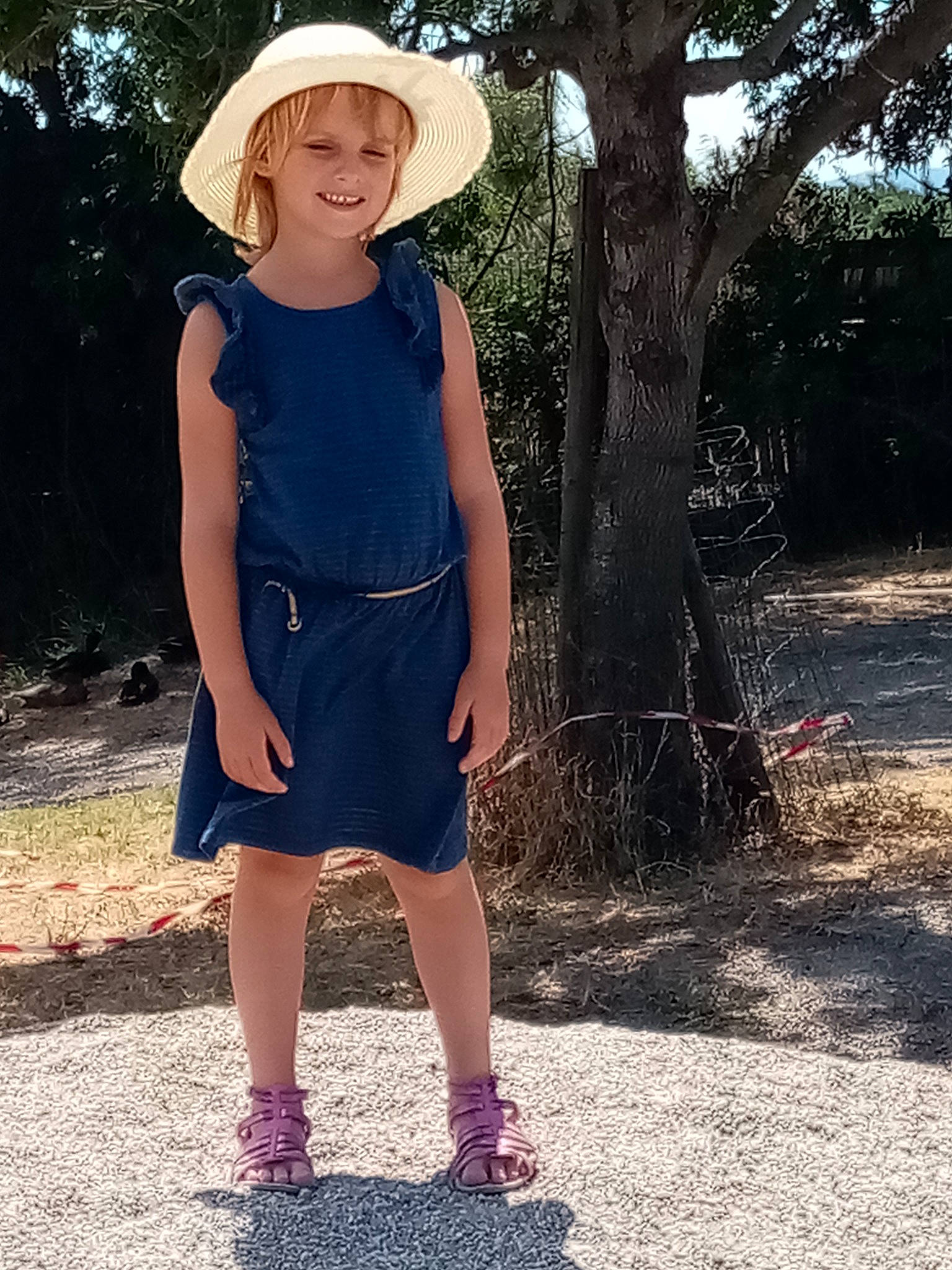 Lilou participe au concours pour gagner de l'argent avec cette photo : day_dress, denim, electric_blue, grass, happy, hat, joy, knee, one_piece_garment, people_in_nature, person, plant, shoulder, sleeve, street_fashion, summer, sun_hat, sunlight, thigh, tree