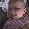 baby, blanket, child, cozy, cute, ear, face, head, indoors, infant, nap, onesie, peaceful, portrait, resting, skin, sleeping, smile, soft, striped_clothing