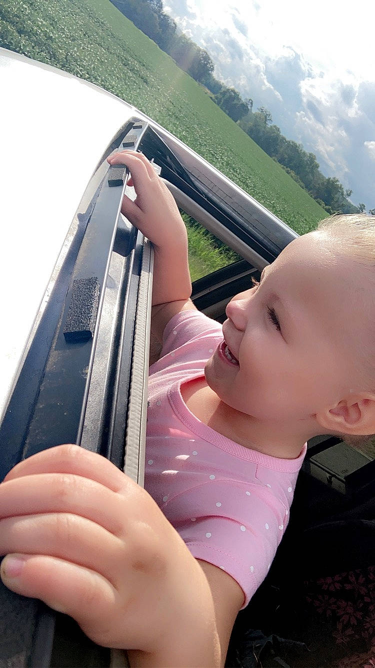 Paisley-grace is registered to the contest to win money with this photo: automotive_exterior, baby_toddler_clothing, cloud, communication_device, finger, fun, gesture, grass, hand, happy, leisure, mobile_phone, person, portable_communications_device, skin, sky, telephony, thumb, travel, tree