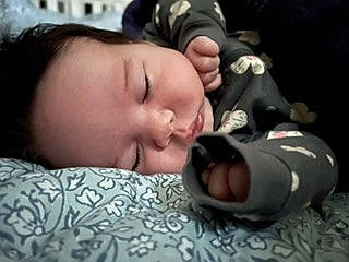 Aries is registered to the contest to win money with this photo: baby, baby_toddler_clothing, black_hair, cheek, child, comfort, ear, eye, eyelash, fun, grass, nap, pattern, person, portrait_photography, sitting, skin, sleeve, smile, thumb