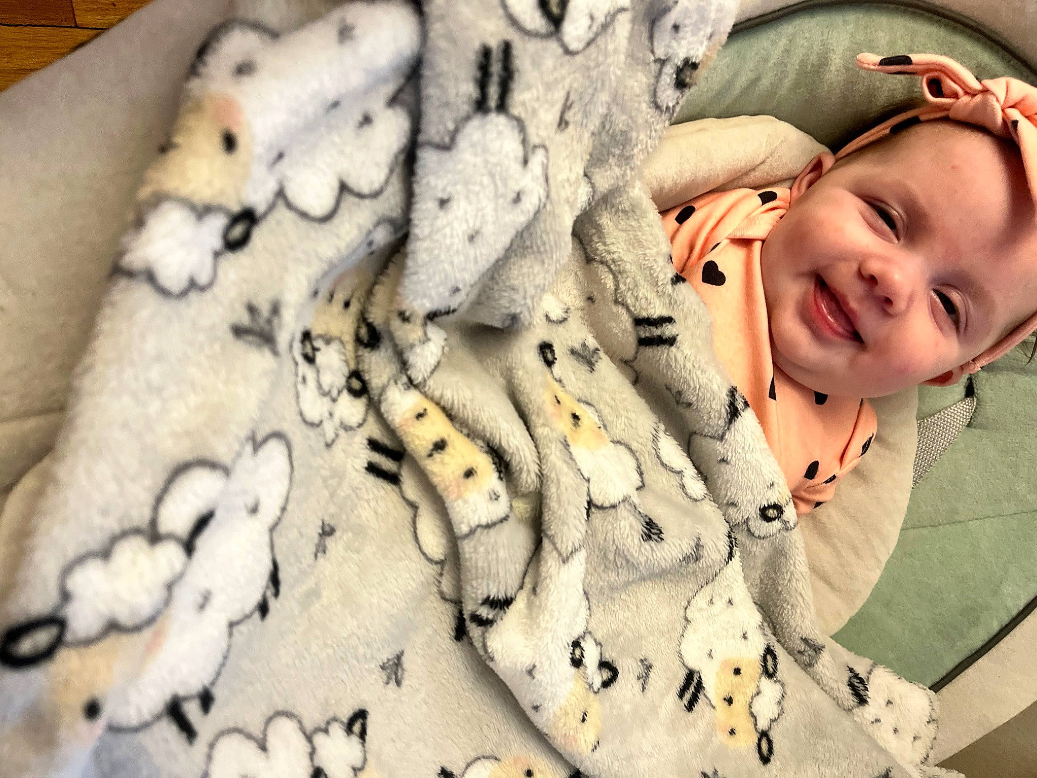 Delilah is registered to the contest to win money with this photo: baby, child, close_up, comfort, fashion_accessory, finger, flash_photography, fur, gesture, happy, headgear, human_leg, joy, linens, nail, pattern, person, skin, sleeve, smile