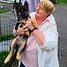 Luna a rejoint le concours — aidez-le/la à gagner de superbes lots ! woman, dog, puppy, german_shepherd, outdoor, fence, glasses, smile, jacket, pink_shirt, bracelet, grass, path, earrings, holding, pet, happy, person, nature, friendly