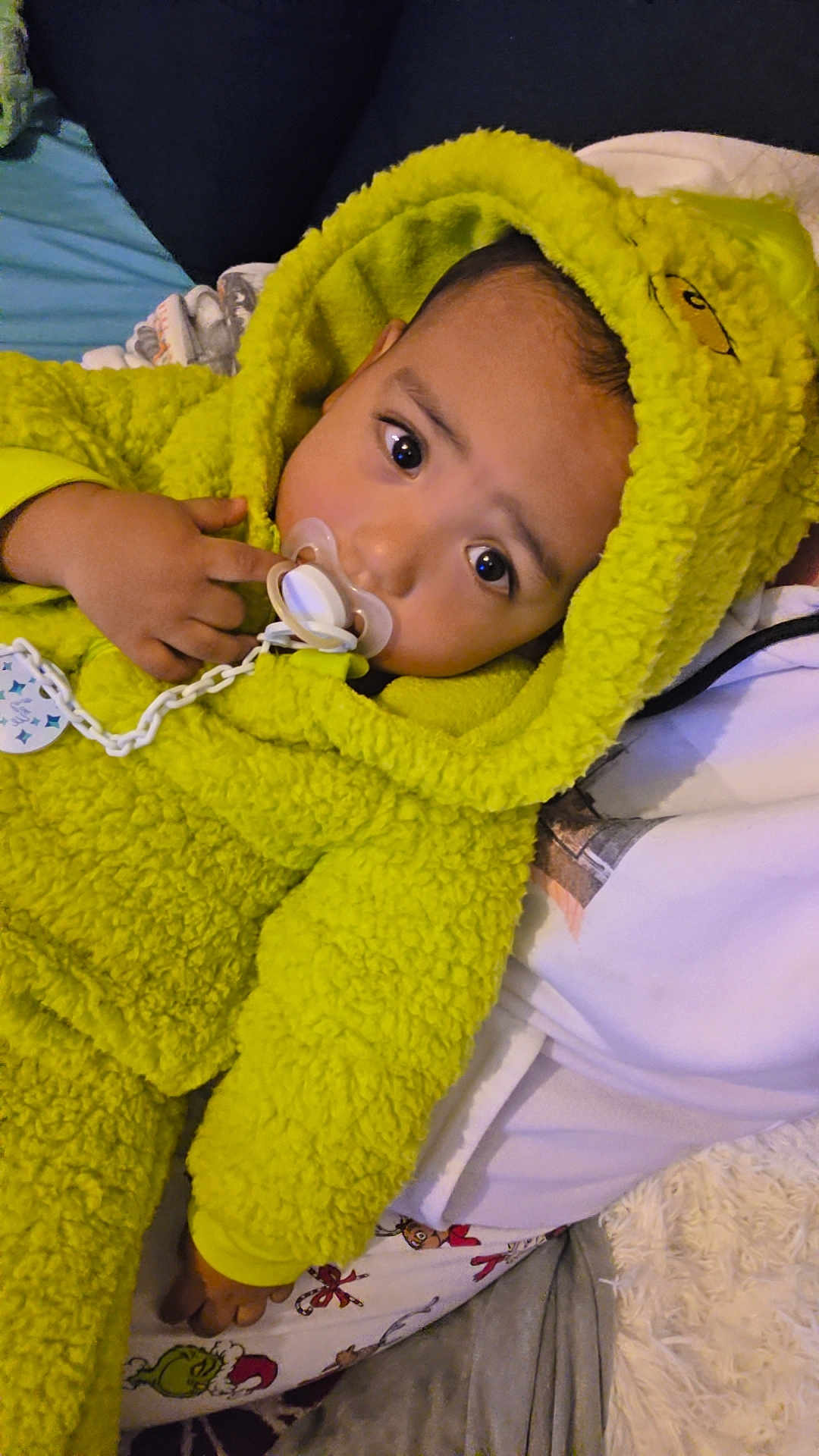 Ylann participe au concours pour gagner de l'argent avec cette photo : baby, child, pacifier, yellow_onesie, hood, fluffy_clothing, cute, indoor, portrait, infant, pajamas, cozy, soft_texture, lying_down, person, face, hand, curious, comfortable, resting