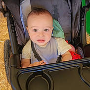 Gadiel is registered to the contest to win money with this photo: baby, babytrend, child, clothing, comfort, curious, expression, face, hand, harness, hay, head, infant, legs, outdoor, person, seat, stroller, toy, young