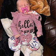 Eleanor joined the competition — help win amazing prizes! newborn, baby, sleeping, pacifier, pink_outfit, floral_clothing, blanket, couch, leather, indoors, portrait, infant, peaceful, headband, clothing, socks, seated, relaxed, closeup, family_photo