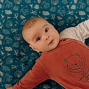 Olympe a rejoint le concours — aidez-le/la à gagner de superbes lots ! baby, infant, child, face, eyes, smile, blanket, pattern, blue, clothing, onesie, bear_illustration, cute, lying_down, indoors, soft_lighting, portrait, closeup, skin, hand