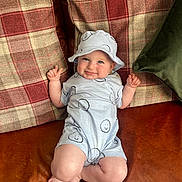 Mason joined the competition — help win amazing prizes! baby, infant, smiling, hat, clothing, couch, leather, plaid, cushion, green_pillow, happy, cute, child, portrait, indoors, feet, hands, face, blue_eyes, relaxed