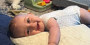 Mason joined the competition — help win amazing prizes! baby, pillow, smile, toy, stuffed_animal, floor, carpet, child, hand, onesie, indoor, playtime, happy, infant, reaching, crawling, colorful, soft_toy, head, expression