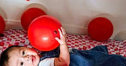 Thiago joined the competition — help win amazing prizes! baby, balloon, blanket, child, clothing, cute, decoration, denim, floor, happy, heart, holding, indoor, infant, pattern, person, playing, red, smiling, wall