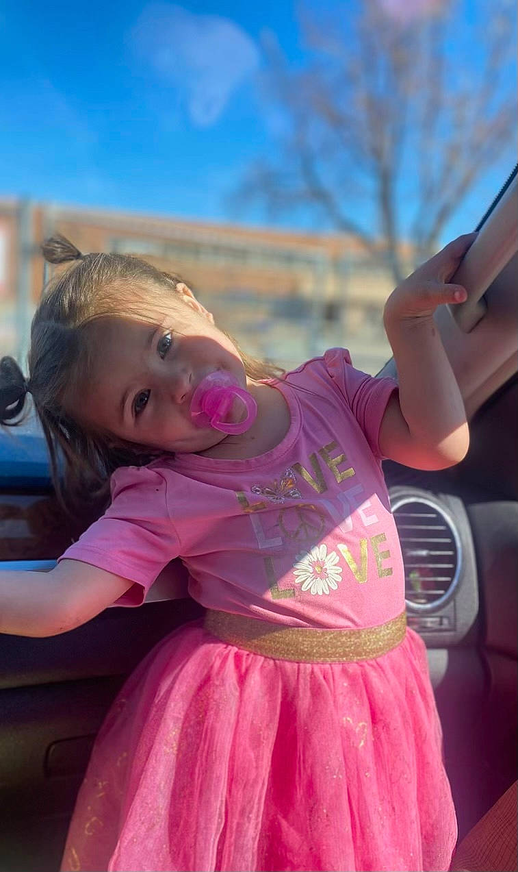 Destiny is registered to the contest to win money with this photo: automotive_exterior, automotive_wheel_system, blond, child, electric_blue, event, family_car, fun, grass, happy, leisure, luxury_vehicle, magenta, person, pink, recreation, sky, smile, toddler, tree