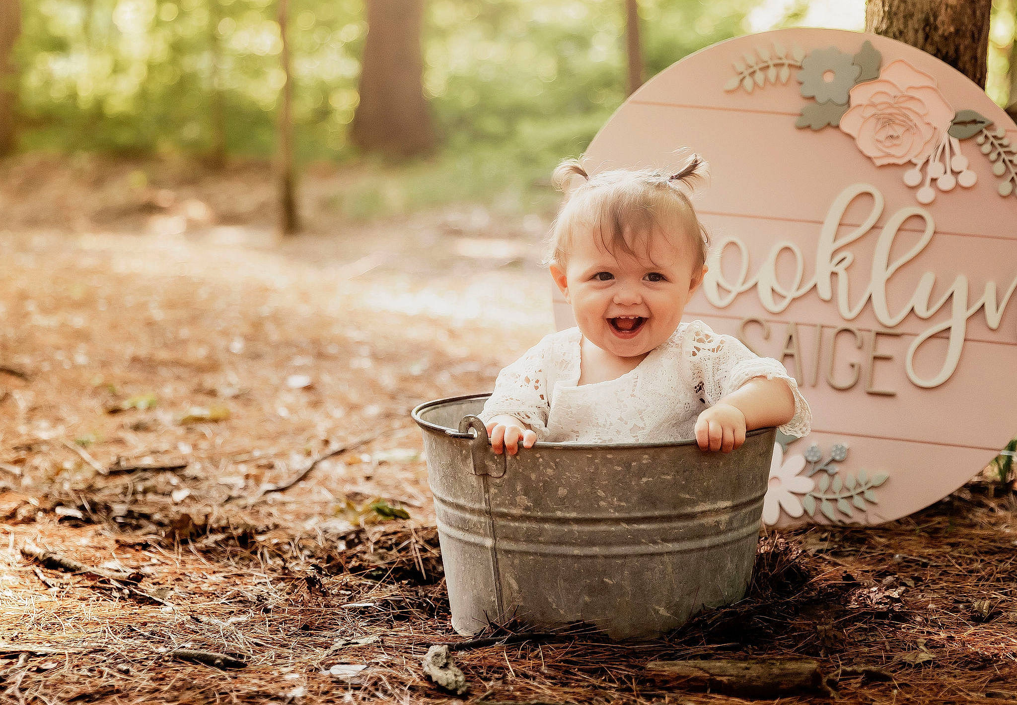 Brooklyn is registered to the contest to win money with this photo: baby, child, dress, eye, forest, fun, grass, hairstyle, happy, joy, leisure, natural_environment, people_in_nature, person, plant, sitting, smile, soil, toddler, tree