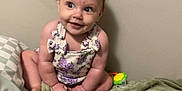 Sophia joined the competition — help win amazing prizes! baby, infant, child, sitting, blanket, toy, colorful, wall, cute, smiling, playful, indoor, person, young, clothing, flower_pattern, skin, head, face, happy