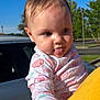 Sophia joined the competition — help win amazing prizes! baby, child, tongue_out, onesie, pink_clothing, elephant_pattern, cloud_pattern, hand, yellow_shirt, person, outdoor, daylight, blue_sky, trees, car, parking_lot, cute, playful, portrait, infant
