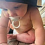 Sophia is registered to the contest to win money with this photo: baby, pacifier, crawling, arm, leg, skin, wood, outdoor, natural_light, close_up, child, infant, headwear, cap, summer, sunlight, planks, curious, bare_skin, young