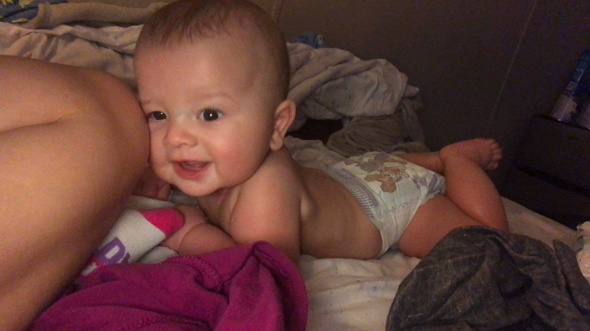 Cayden is registered to the contest to win money with this photo: baby, cheek, chest, comfort, dress, ear, eye, eyebrow, finger, flash_photography, hand, happy, human_body, iris, lip, mouth, nose, person, skin, smile