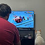 Kimchi joined the competition — help win amazing prizes! back_view, cable, cat, electronics, entertainment, furniture, game_controller, gaming, indoor, living_room, man, notebook, power_outlet, red_shirt, shelf, television, ufc, video_game, watching, white_cat