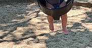 Joshua joined the competition — help win amazing prizes! barefoot, blue_chair, casual_clothing, chains, child, curious, daytime, fun, grass, nature, outdoor, park, people, playground, recreation, sand, shadow, sunlight, swing, toddler