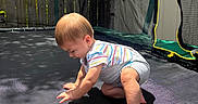 Joshua joined the competition — help win amazing prizes! baby, barefoot, child, crouching, curious, daylight, fence, gray_shorts, nature, netting, outdoor, play, shadow, striped_shirt, summer, sunlight, toddler, trampoline, trees, young_child