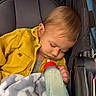 baby, blanket, bottle, child, closed_eyes, corduroy, cozy, fabric, face, hair, indoors, infant, milk_bottle, nap, photography, portrait, seated, sleeping, stroller, yellow_jacket
