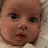 Erin joined the competition — help win amazing prizes! baby, infant, face, wide_eyes, curious, close_up, blanket, star_pattern, soft_lighting, skin, cheeks, mouth, clothing, sleepwear, newborn, portrait, indoors, cute, expression, child