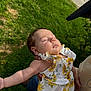 Tilly joined the competition — help win amazing prizes! baby, infant, sleeping, child, outdoor, green_grass, floral_dress, person, holding, sunlight, nature, cute, peaceful, summer, skin, hand, head, face, arm, resting