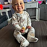 Wyatt is registered to the contest to win money with this photo: baby, child, pajamas, table, fruit, smile, indoor, furniture, cabinet, lamp, living_room, person, cute, seated, home, happy, clothing, infant, face, cozy