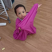 Keyana a rejoint le concours — aidez-le/la à gagner de superbes lots ! baby, child, clothing, curious, drying_rack, expression, face, floor, footwear, furniture, hand, home, indoor, person, playful, purple_cloth, room, sitting, toddler, wooden_floor