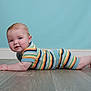 Luca is registered to the contest to win money with this photo: baby, blue_wall, cheeks, child, clothing, crawling, curious, cute, floor, head, indoor, infant, knitwear, pastel_wall, person, portrait, skin, smiling, striped_clothing, wooden_floor