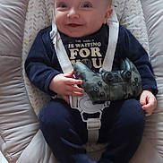 Maëlyo participe au concours pour gagner de l'argent avec cette photo : baby, baby_seat, bouncer, camouflage, feet, floor, game_controller, hands, happy, harness, high_angle_shot, indoor, infant, navy_clothing, onesie, padded_seat, portrait, smiling, table_corner, tiles