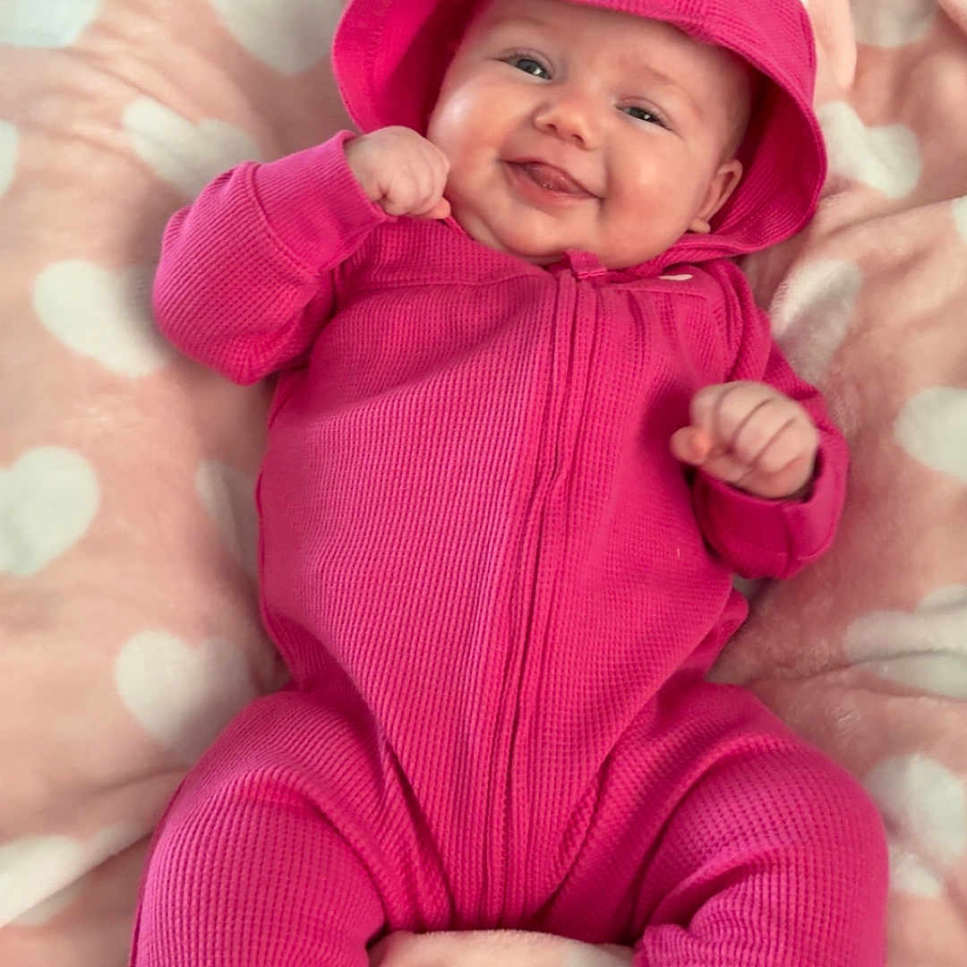 Mekhiyah is registered to the contest to win money with this photo: baby, child, chubby_cheeks, cozy, cute, fabric, hands, happy, heart_blanket, hood, infant, infant_garment, laying, nursery, pink_onesie, playful, portrait, smiling, soft_texture, toes