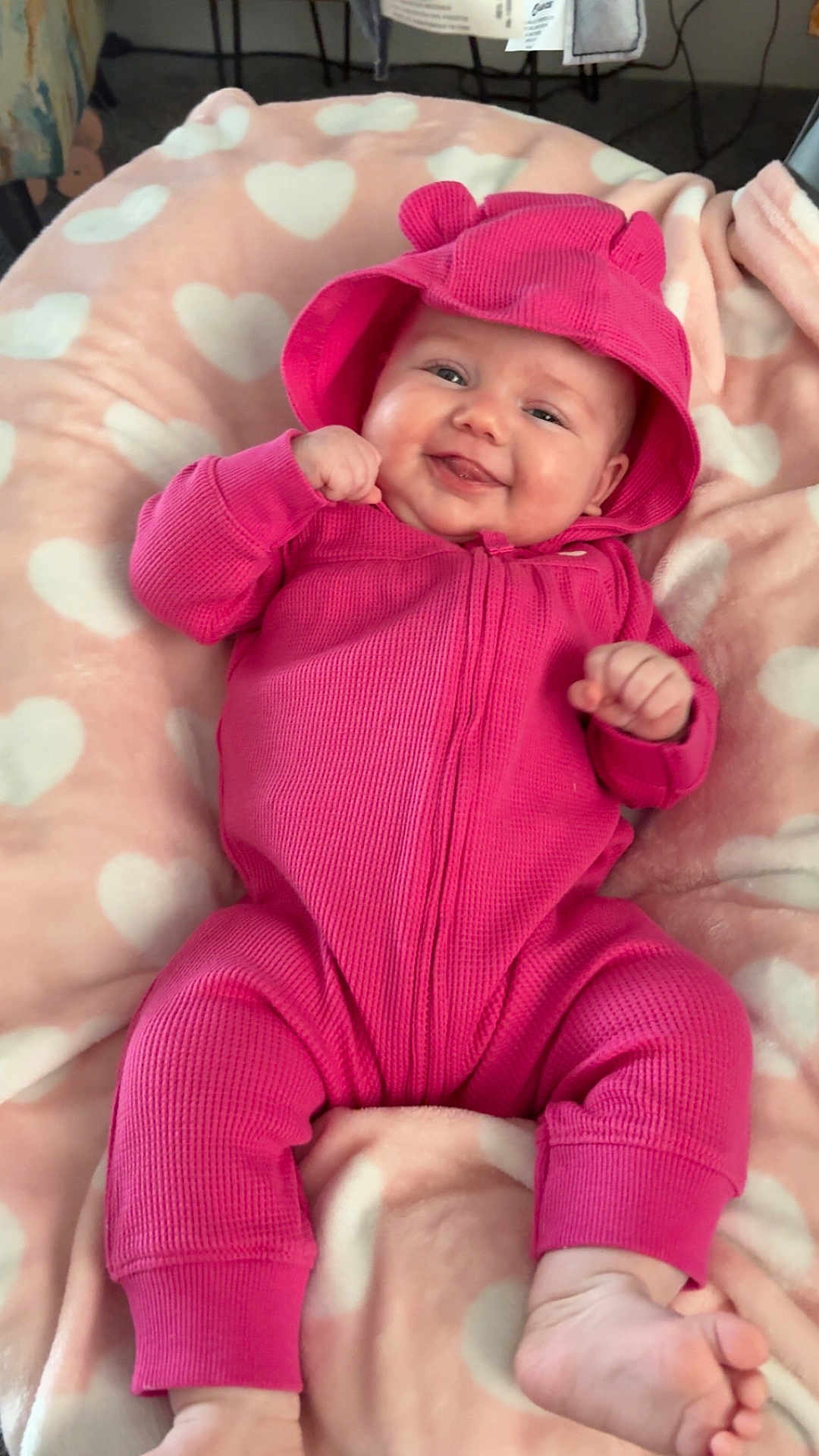 Mekhiyah is registered to the contest to win money with this photo: baby, child, infant, smiling, pink_onesie, hood, heart_blanket, cozy, chubby_cheeks, toes, hands, laying, portrait, cute, nursery, soft_texture, playful, fabric, infant_garment, happy