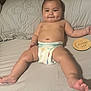 baby, diaper, smiling, dimple, bed, pillow, plush, skin, bare_chest, infant, wooden_plaque, text, cute, lying_down, indoors, child, person, young, happy, relaxed