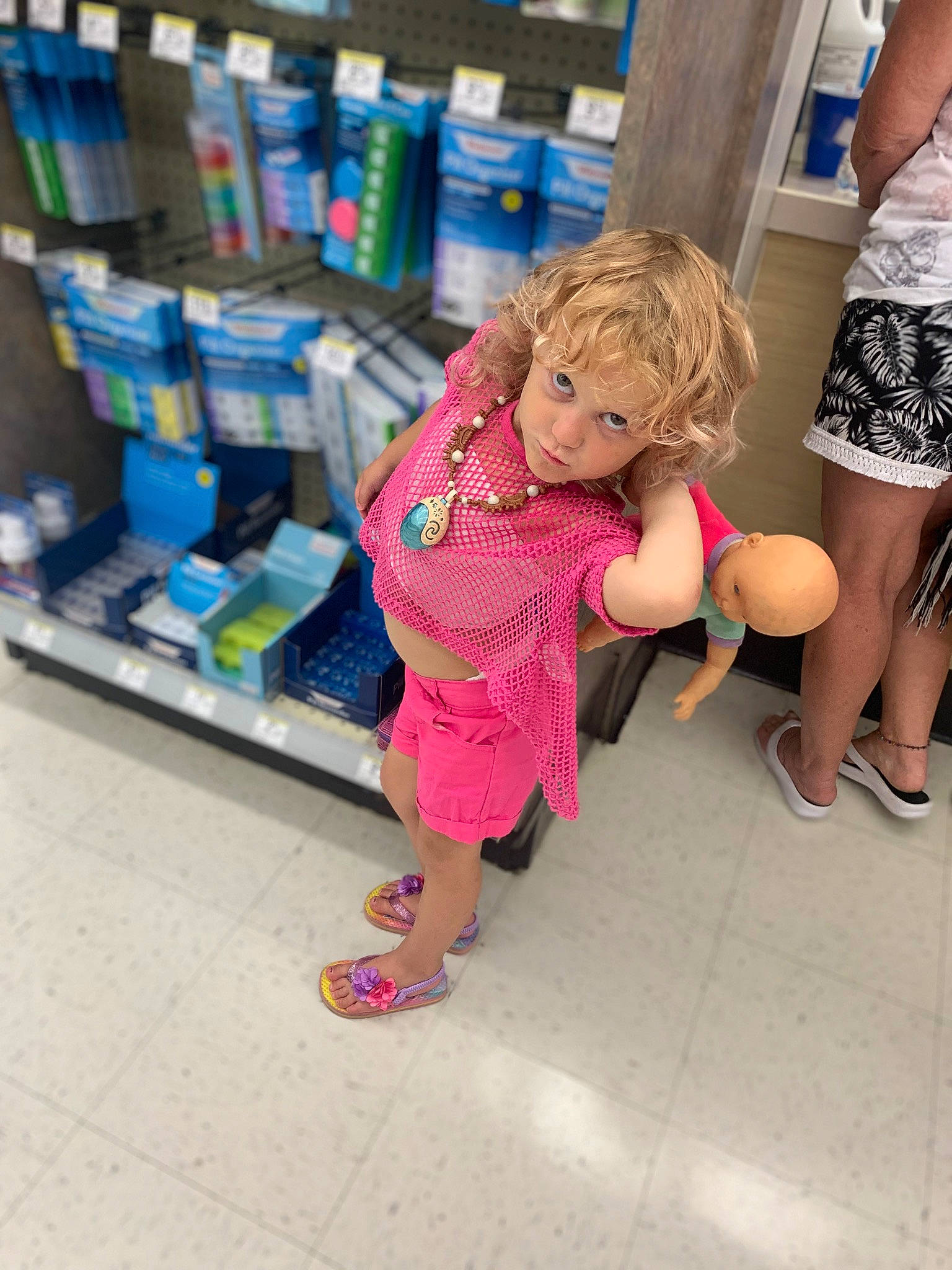 Avonna is registered to the contest to win money with this photo: child, doll, flip_flops, footwear, fun, human_leg, joint, leg, leisure, person, publication, retail, sandal, shelf, shelving, shoe, shopping, sneakers, street_fashion, thigh