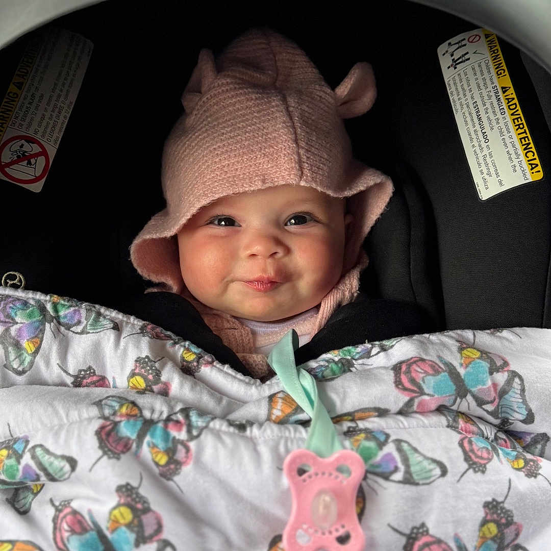 Isabella is registered to the contest to win money with this photo: baby, baseballcap, bonnet, cap, clothing, coat, cushion, face, happy, hat, head, homedecor, jacket, newborn, person, photography, portrait, sleeping, smile, stroller
