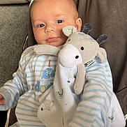 Frankie joined the competition — help win amazing prizes! baby, infant, plush_toy, giraffe, blue_eyes, striped_pajamas, smile, face, child, seated, soft_toy, cute, indoor, cozy, blanket, cushion, comfort, portrait, young_child, happy