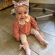 Hanaé a rejoint le concours — aidez-le/la à gagner de superbes lots ! toddler, child, smiling, bow_headband, pink_socks, lace_collar, sitting, floor, tiles, indoor, cute, happy, clothing, portrait, baby, headwear, feet, playroom, person, young_child