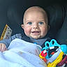 Evann participe au concours pour gagner de l'argent avec cette photo : baby, blue_eyes, smile, blanket, car_seat, toy, colorful, infant, happy, child, face, person, cute, clothing, striped_shirt, indoors, closeup, head, cheeks, seatbelt