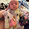Kaiser is registered to the contest to win money with this photo: baby, bed, blanket, child, cozy, cute, expression, fashion, handbags, holding, home, indoor, infant, onesie, pacifier, person, plush, sitting, soft_lighting, star_pattern
